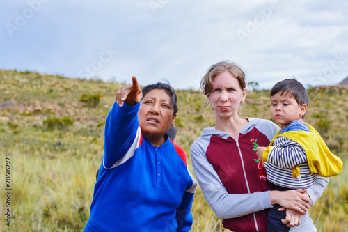 Young caucasian woman with her little son asking the way to the native american woman in the countryside.