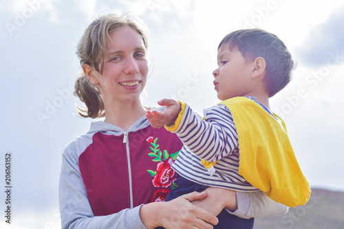 Happy caucasian woman with her sad latin son in the countryside. 
