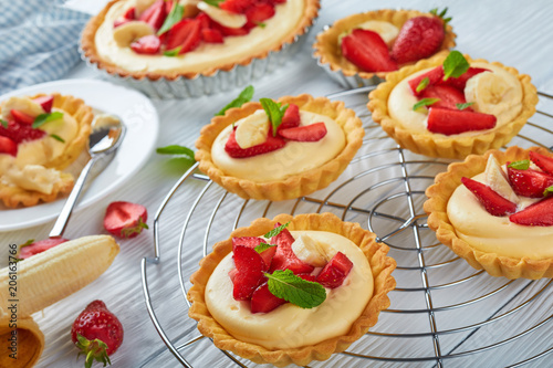 tartlets and tart with strawberries, banana, mint