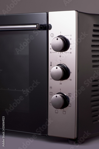 thermostat and handles on a modern microwave. kitchen equipment