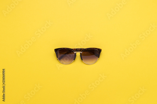Sunglasses on a yellow background. Concept of Travel and Holidays. Flat lay, top view