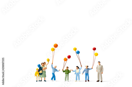 Miniature people : Happy family holding balloon on white background photo