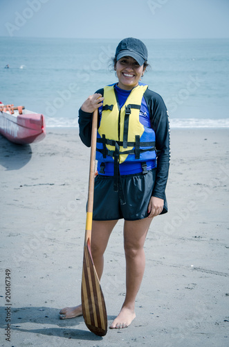 Young woman paddler smiling with an oar in hand photo