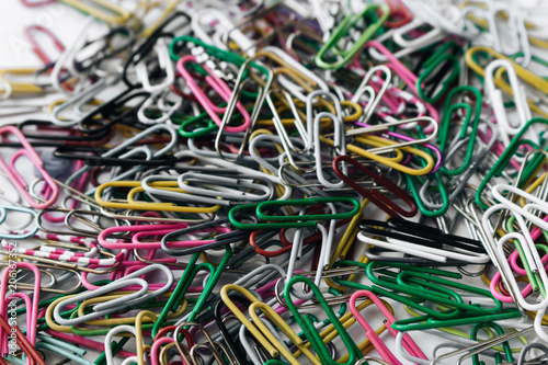 Pile of colorful paper clips on white background  flat lay