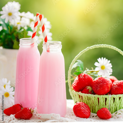 Strawberry cocktail or milkshake in a jar, basket with strawberries on a picnic, healthy food for Breakfast and snacks. Selective focus.