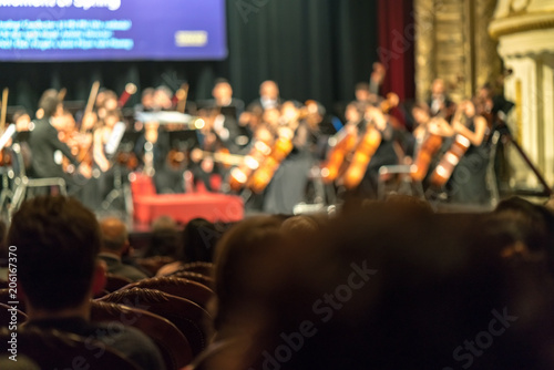 Blurred Audience in a theater, on a concert. Viewers watching the show.