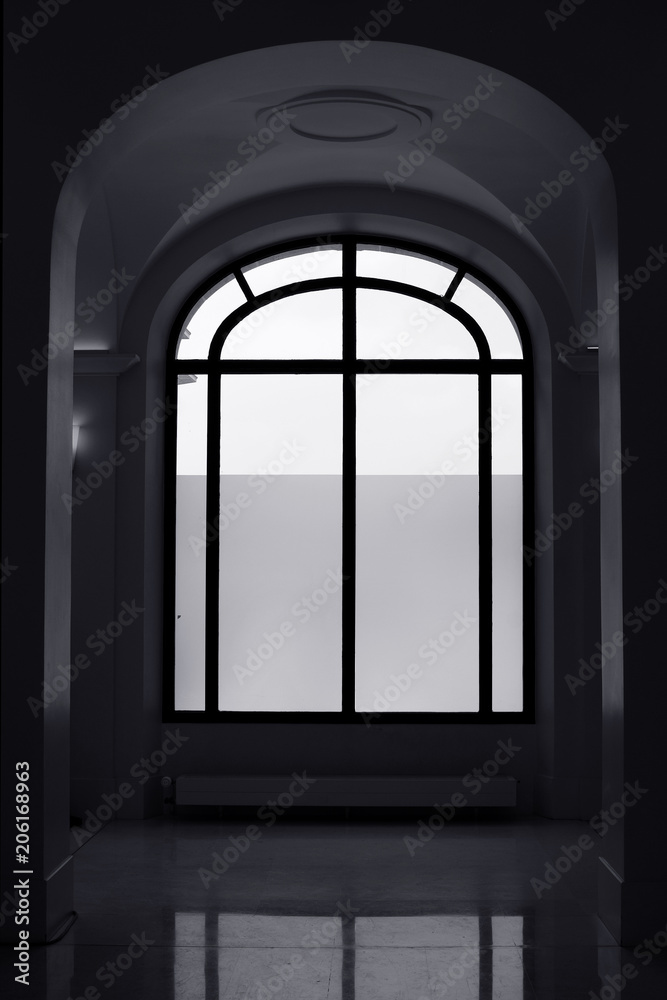 Big window and arched hallway. Black and white.