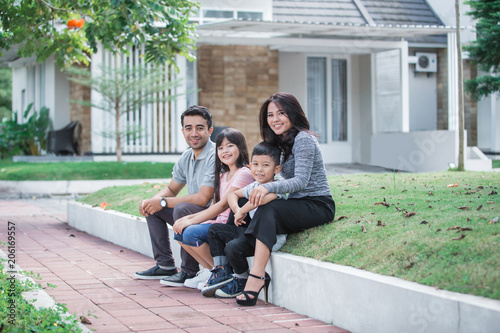 happy asian family in front of their house