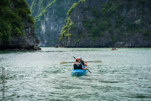 Tourists paddling kayak on Halong bay in Vietnam, UNESCO World Heritage Site