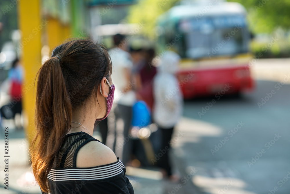 Young girl waiting for bus at bus station. Closeup.