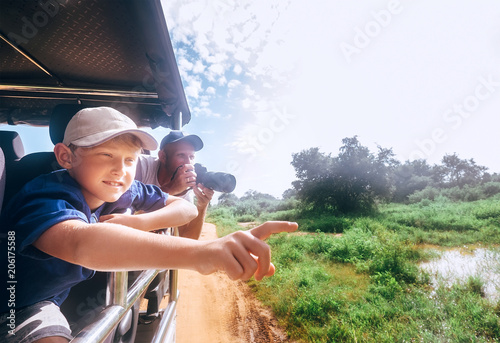 Photography Son and father saw the animals on safari in nature park