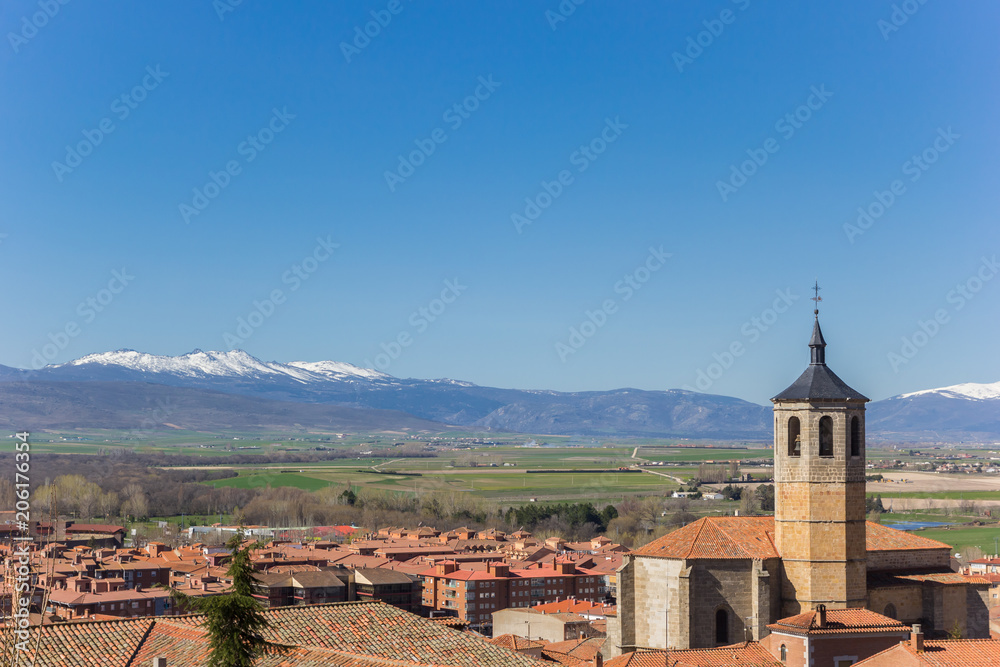 Church tower and snowcapped mountains near Avila, Spain