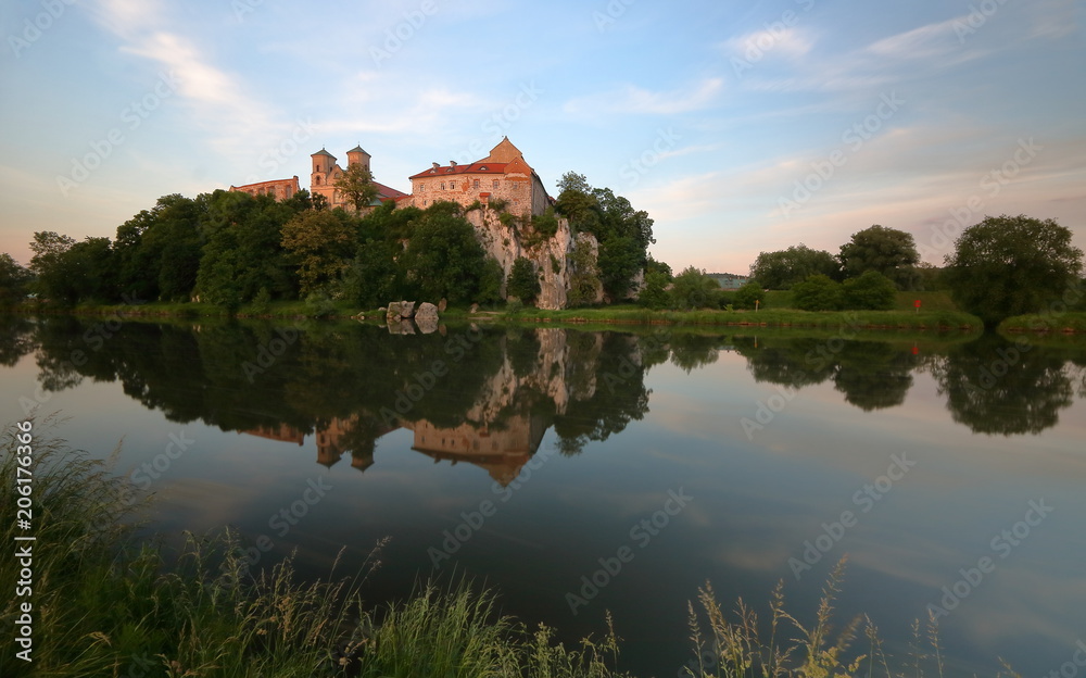 Opactow benedyktynów w Tyńcu pod Krakowem, widok z przeciwnego brzegu rzeki Wisły, w wodzie odbija się bryła budowli, skała, okoliczna roślinność