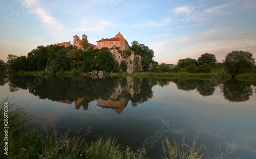 Opactow benedyktynów w Tyńcu pod Krakowem, widok z przeciwnego brzegu rzeki Wisły, w wodzie odbija się bryła budowli, skała, okoliczna roślinność