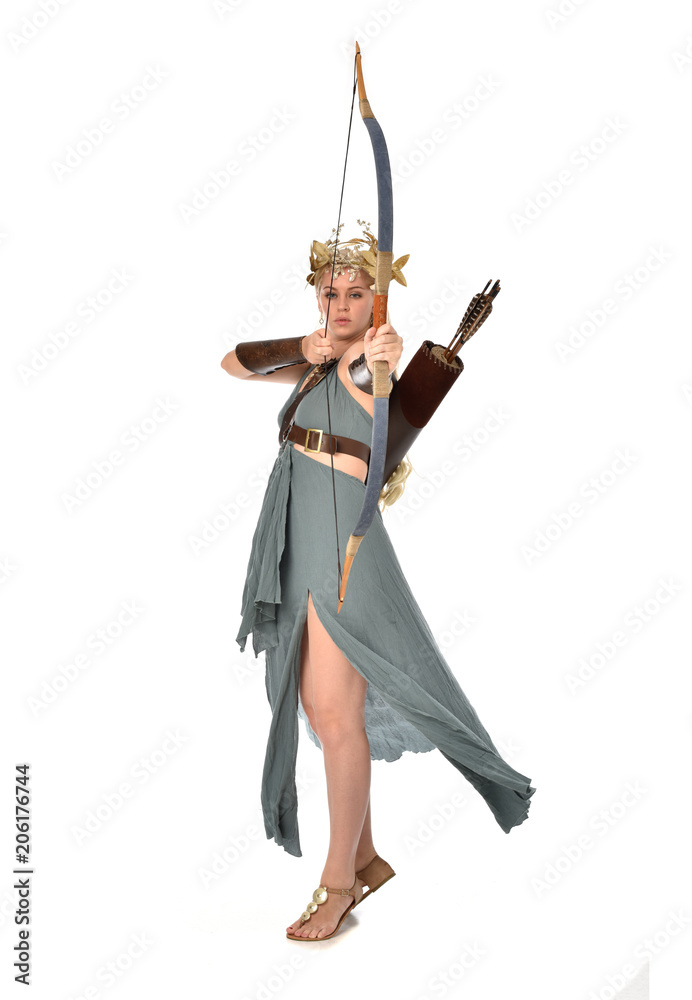 full length portrait of pretty blonde lady wearing fantasy toga gown, and holding a bow and arrow. standing pose on white background. full length portrait of pretty blonde lady wearing fantasy toga gown, and holding a bow and arrow. standing pose on white background.