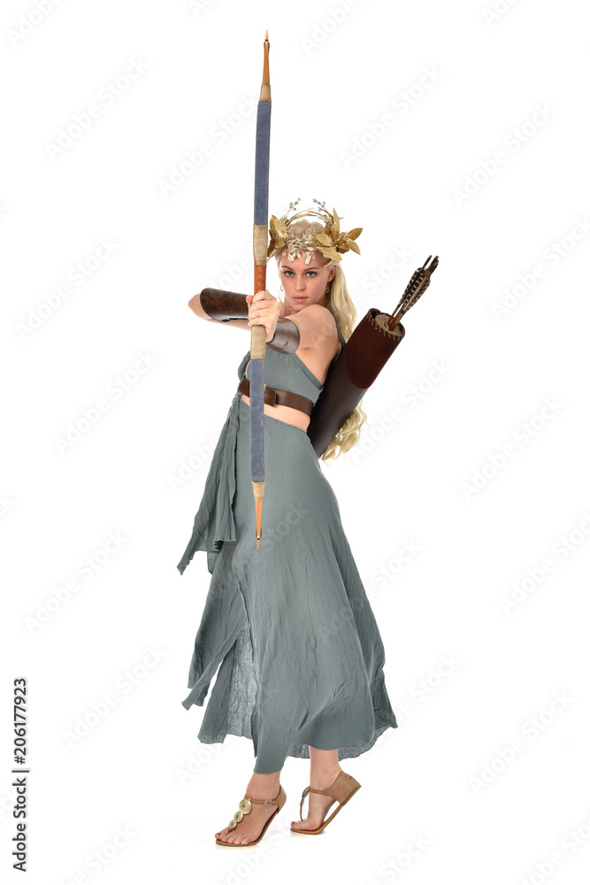full length portrait of pretty blonde lady wearing fantasy toga gown, and holding a bow and arrow. standing pose on white background. full length portrait of pretty blonde lady wearing fantasy toga gown, and holding a bow and arrow. standing pose on white background.