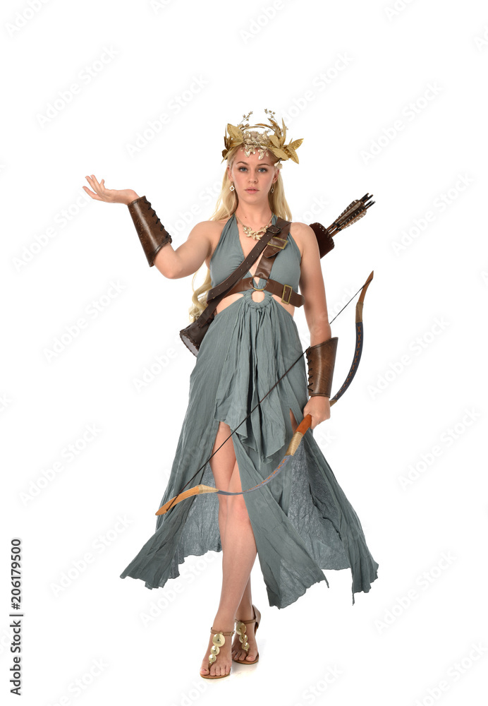 full length portrait of pretty blonde lady wearing fantasy toga gown,  and holding a bow and arrow. standing pose on white background.
