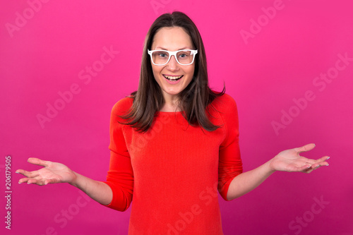 Wow! Surprised young girl with glasses on a pink background. Happy woman.
