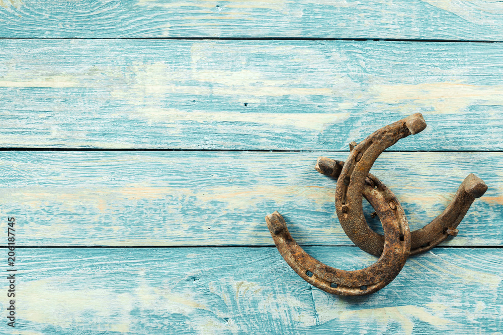 old rusty horseshoes on wooden board old rusty horseshoes on wooden board
