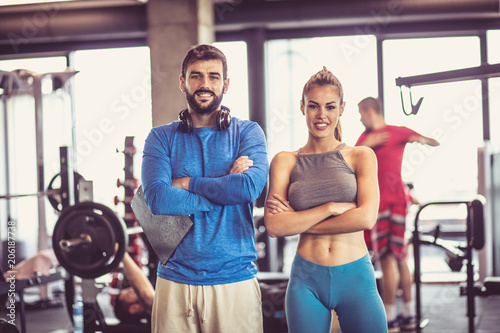 Portrait of smiling man and woman in gym.