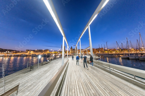 BARCELONA - MAY 11, 2018: Tourists along the city port on a spring night. The city attracts 10 million tourists annually
