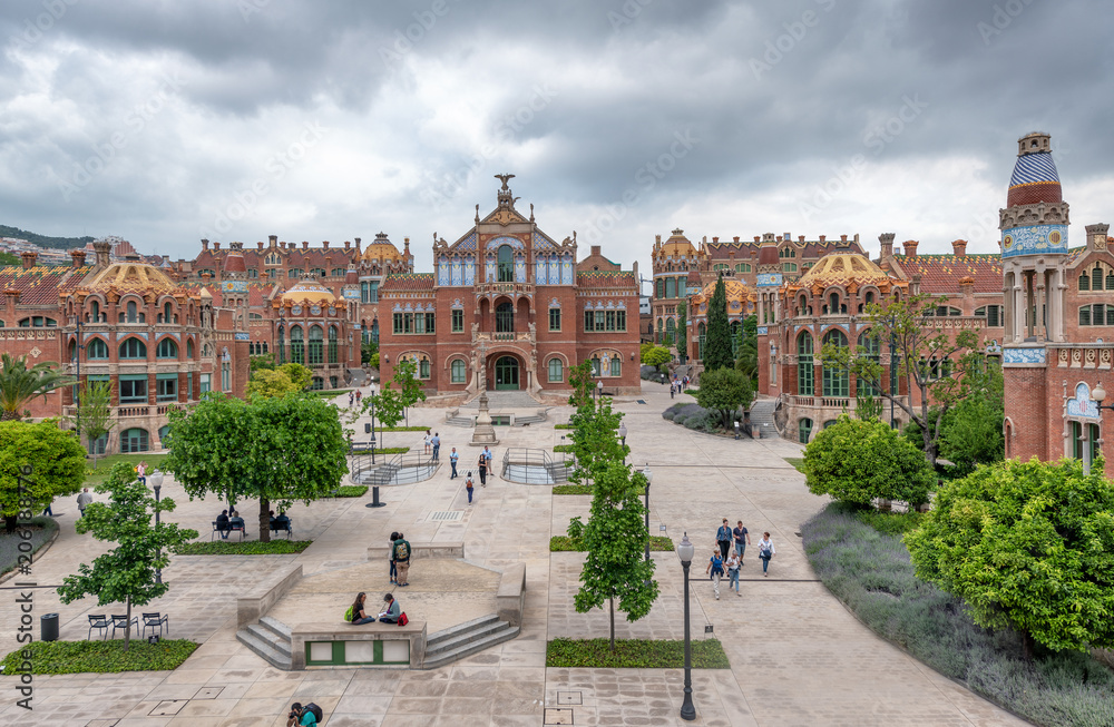 Naklejka premium BARCELONA, SPAIN - MAY 12, 2018: People visit Recinte Modernista de Sant Pau. The city attracts 10 million tourists annually