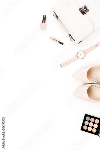 Fashion blogger workspace flat lay with pumps, cosmetics, purse, planner book and flowers.