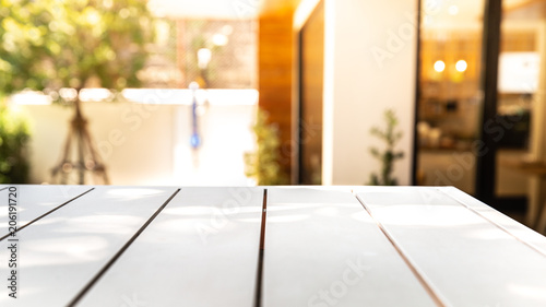 Empty wood white table and blurred cafe or restaurant light background.