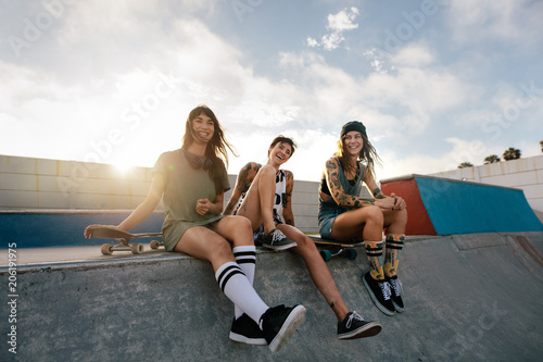 Group of women sitting on ramp in skate park
