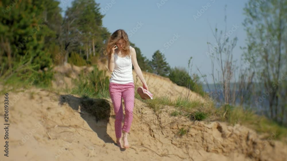 Young woman using a smartphone in a forest. Beautiful girl typing on phone in the woods. Young woman using a smartphone in a forest. Beautiful girl typing on phone in the woods.