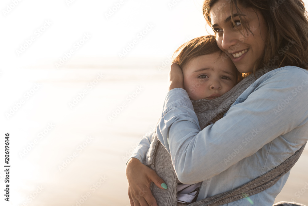 Fototapeta premium Mother carrying baby
