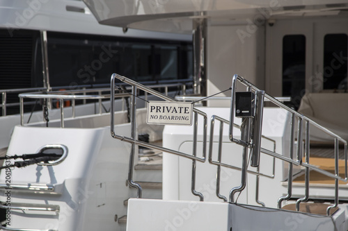 Private gangplanks and access to luxury yachts with signboards and electronic control panels leading to the deck in a close up view