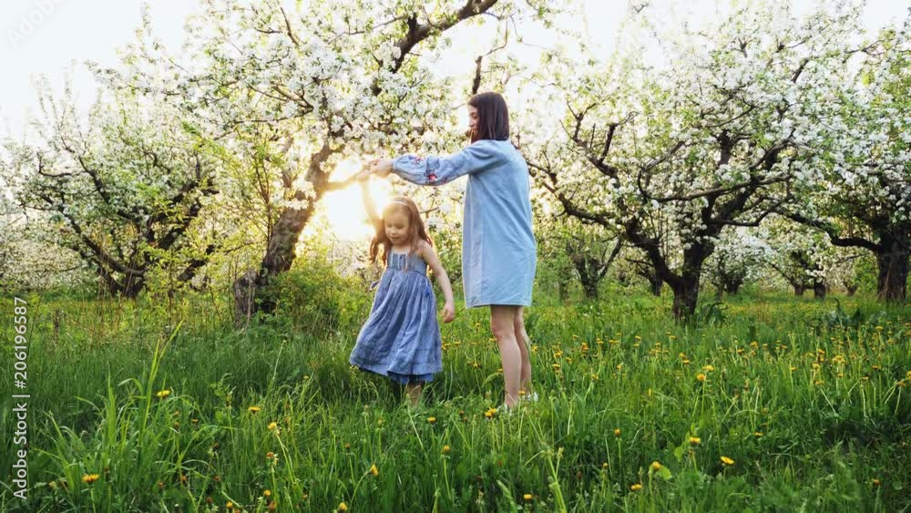 Young mother with her adorable five year old girl playing outdoors with love. Concept of family love of nature Young mother with her adorable five year old girl playing outdoors with love. Concept of family love of nature