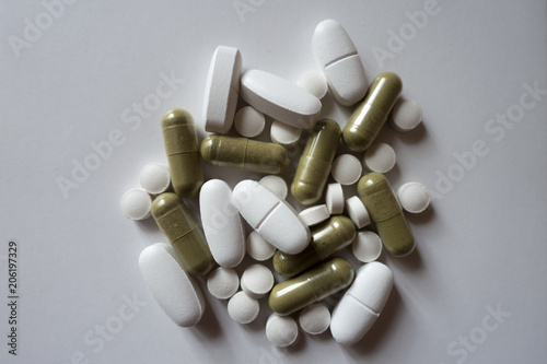 Heap of green and white pills from above