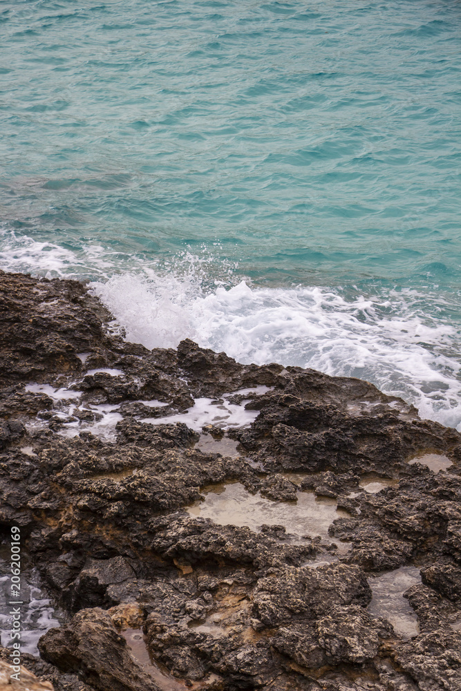 Wave meets the limestone rocky coast at Blue Lagoon Bay, Comino Island, Malta