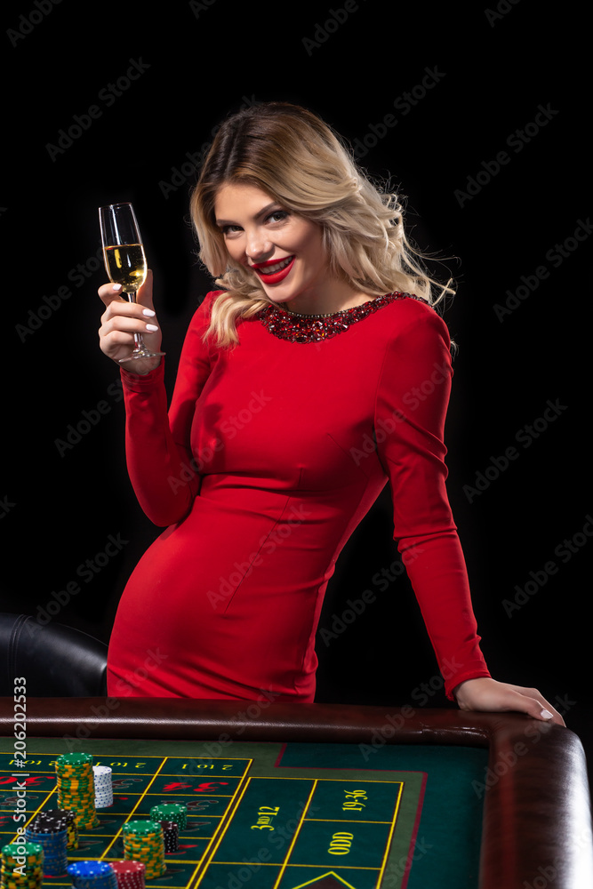 Young blonde woman wearing beautiful red dress is playing roulette in the  casino Stock Photo | Adobe Stock