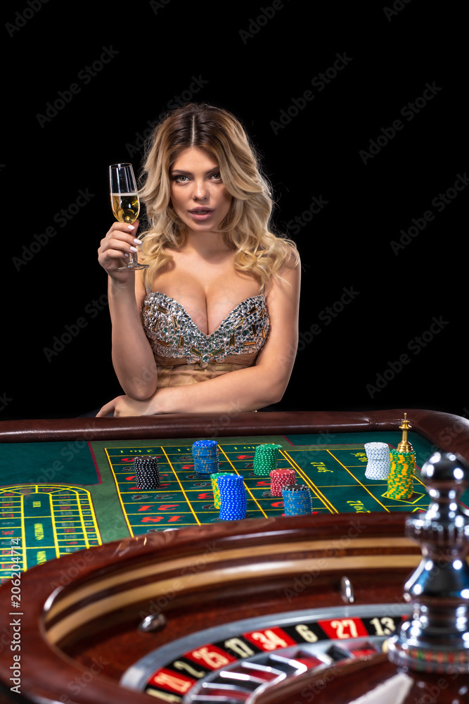 Young blonde woman wearing beautiful sexy shiny dress is playing roulette  in the casino Stock Photo | Adobe Stock