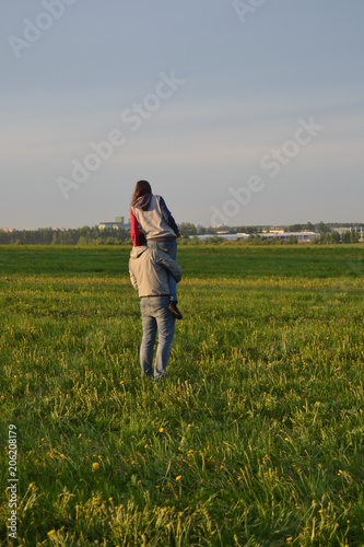  friends or couple in the green field with blue sky