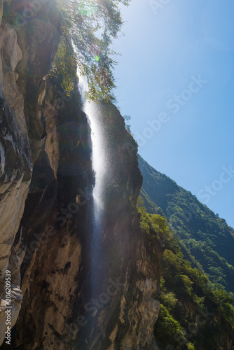 Waterfall at Flat tour-tourism artificial walking street that runs near the water on the right side of the river. Tiger Leaping Gorge near Lijiang Ancient Town in Yunnan, China © joesayhello