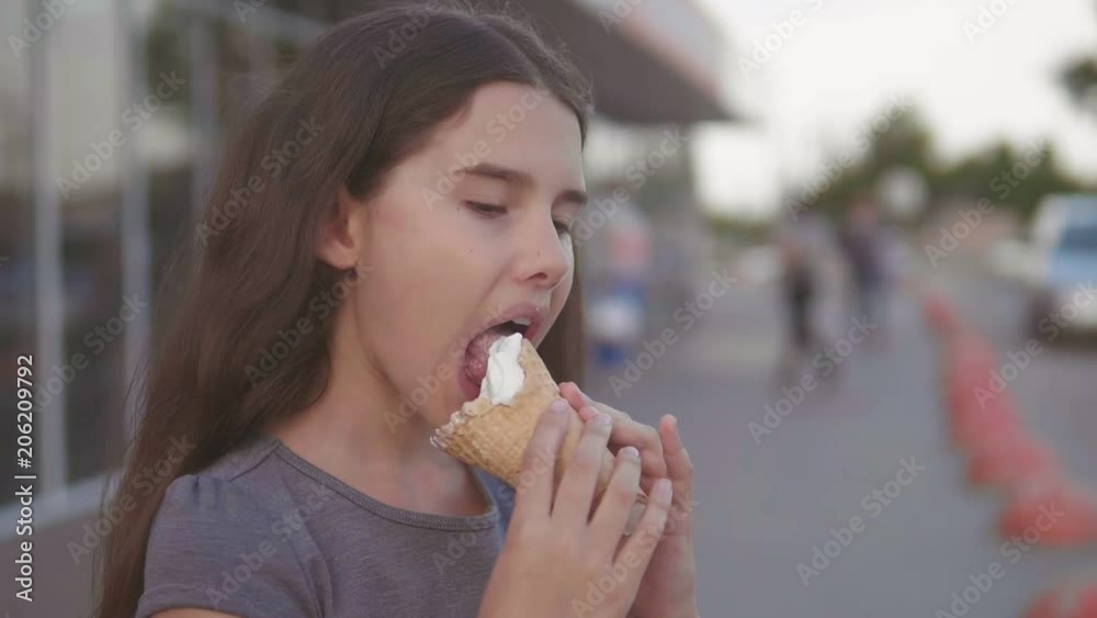 little girl eating ice cream goes down the street in the city next to the supermarket with a soft toy motion slow motion video lifestyle. girl and ice cream urban eat concept little girl eating ice cream goes down the street in the city next to the supermarket with a soft toy motion slow motion video lifestyle. girl and ice cream urban eat concept