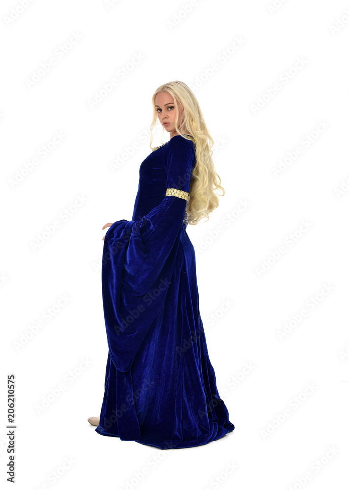 full length portrait of pretty blonde lady wearing  a blue fantasy medieval gown. standing pose on white background.