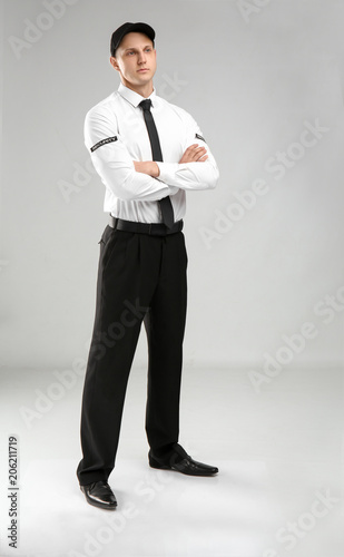 Male security guard in uniform on color background © New Africa