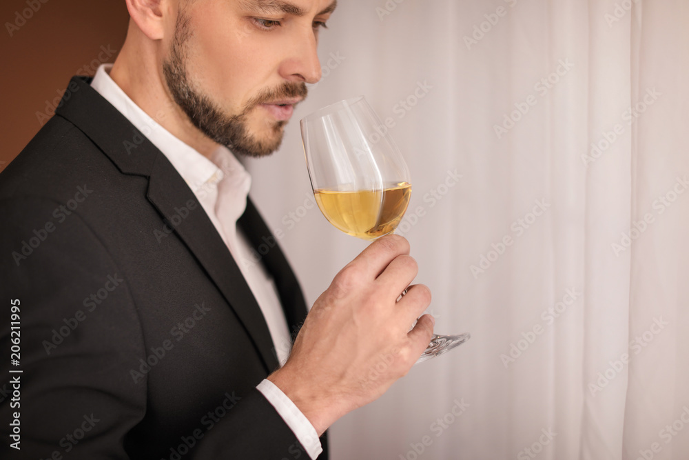 Young man with glass of wine indoors Young man with glass of wine indoors