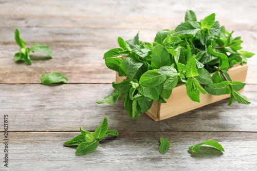 Wooden crate with fresh mint on table