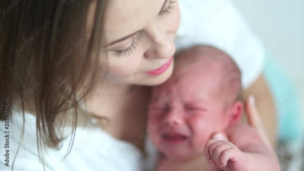 Mother and child. Mom calms, cradles a crying newborn baby. Mothers Day Mother and child. Mom calms, cradles a crying newborn baby. Mothers Day