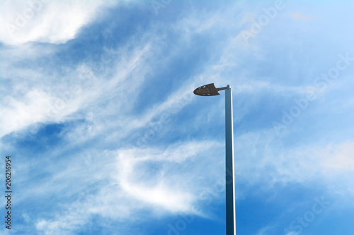 metal lamp post and white cloud on blue sky with light form the sun in the morning