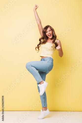 Billede på lærred Full length photo of pleased woman 20s with long brown hair rejoicing and scream