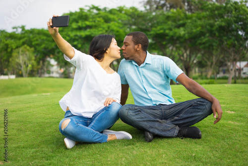 Romantic young couple kissing and taking selfie with phone