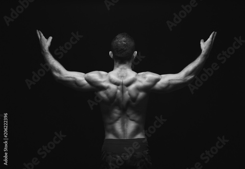 Unrecognizable man shows strong back muscles closeup