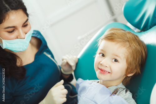 Female dentist doctor and little patient at office